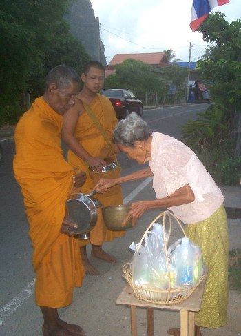 Thais give food during alms round in Thailand